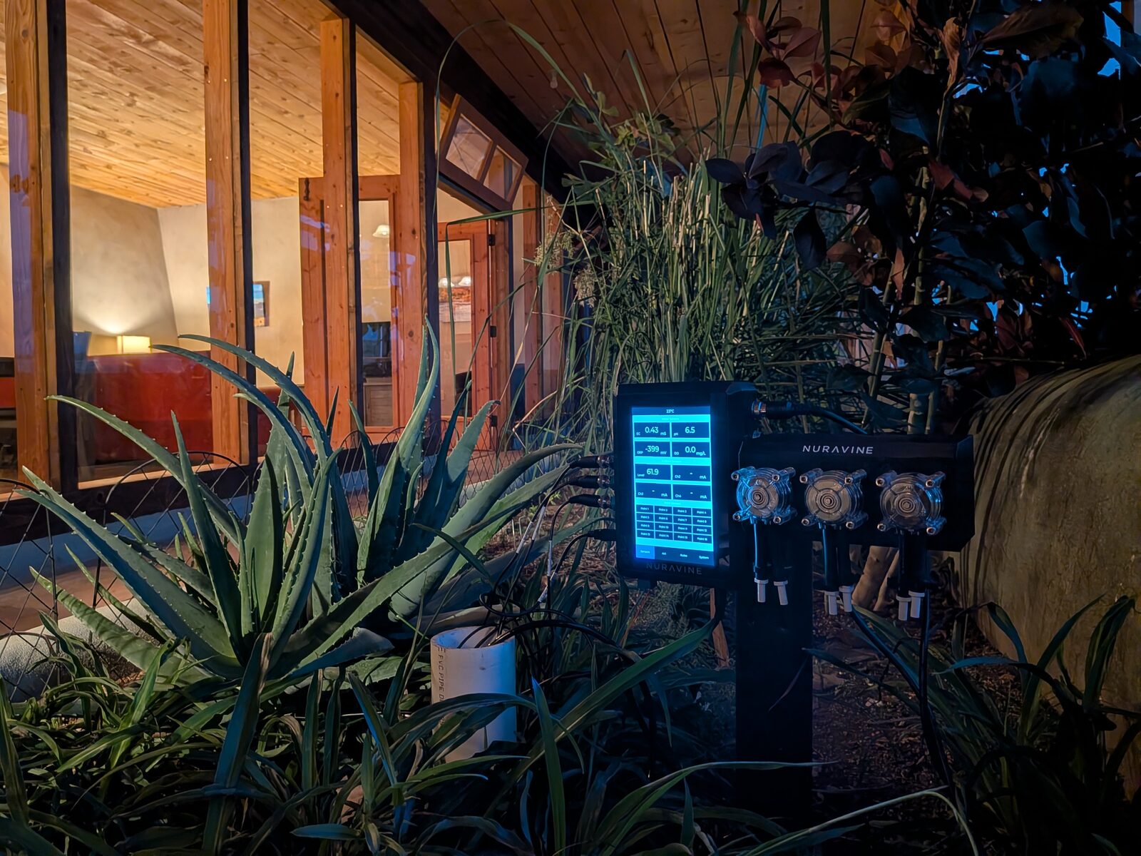Nuravine sensor controller and dosing pumps installed in the Encounter Earthship greywater planter at night